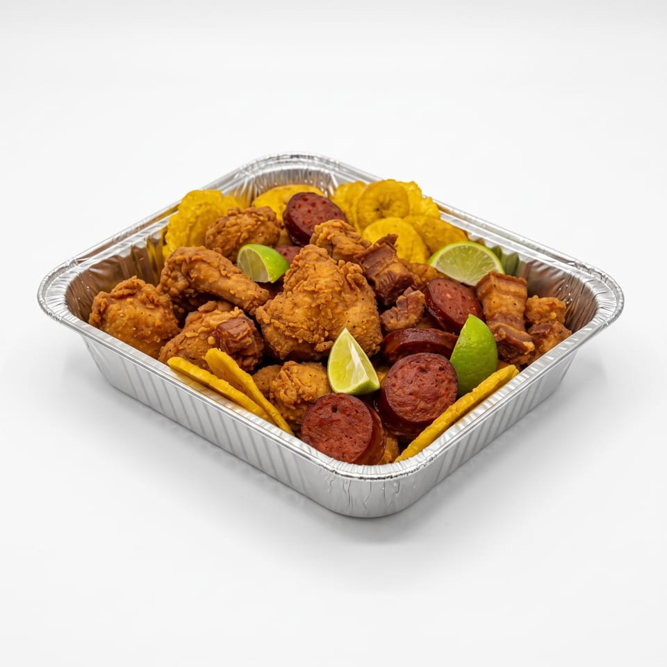 Aluminum tray filled with fried chicken, sausage slices, fries, plantains, and lime wedges.